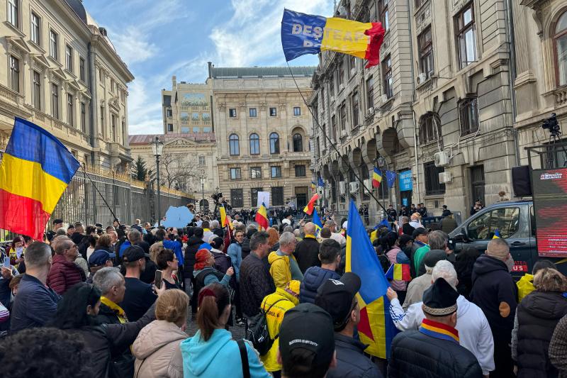 Călin Georgescu își va depune candidatura pentru alegerile prezidențiale. Mii de susținători îi sunt alături la Biroul Electoral Central, purtând steaguri tricolore și pancarte.